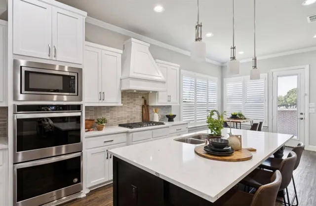 a kitchen with a stove a microwave a sink a dining table and chairs