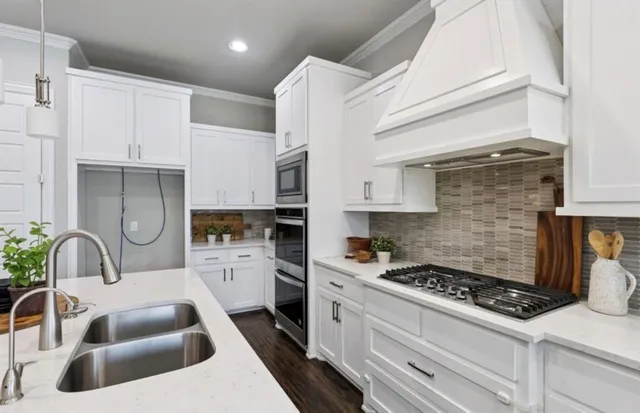 a kitchen with sink stove and white cabinets