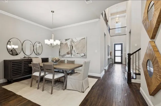 a view of a dining room with furniture a chandelier and wooden floor