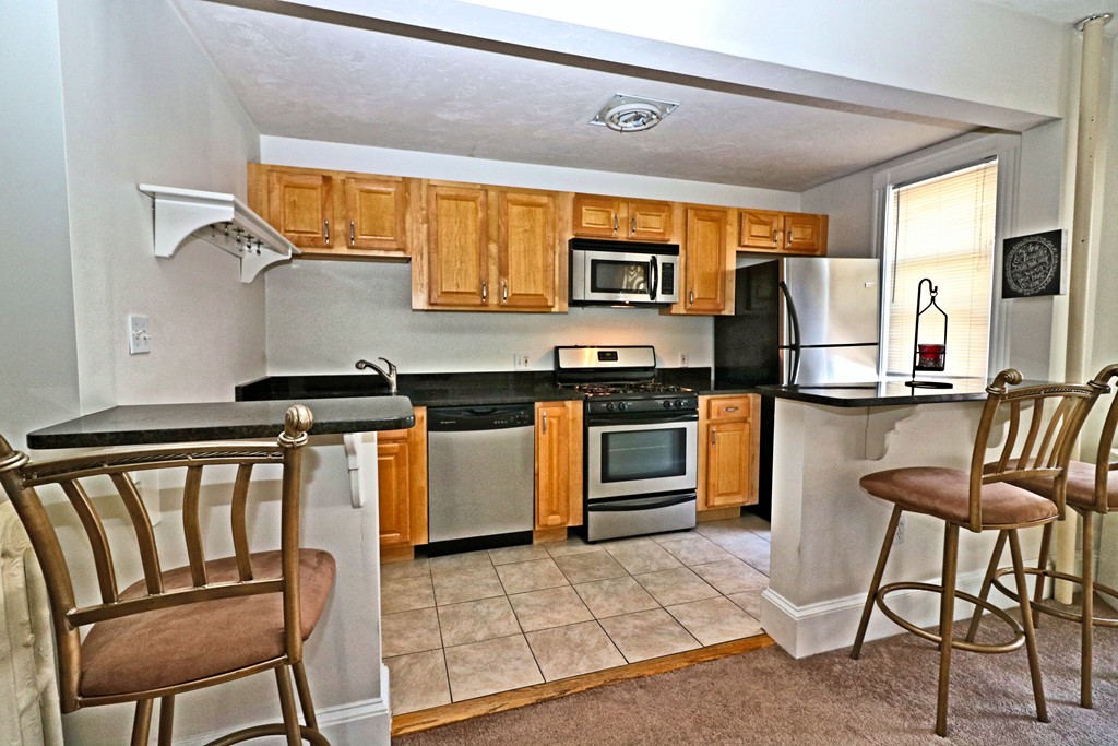 53 Trident Avenue, Unit 103 Winthrop, MA 02152 - Photo 3 of 16 a kitchen with stainless steel appliances granite countertop a stove a sink dishwasher and a refrigerator