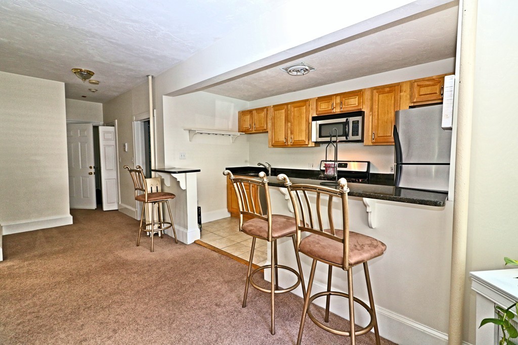 53 Trident Avenue, Unit 103 Winthrop, MA 02152 - Photo 7 of 16 a view of kitchen with furniture and a refrigerator