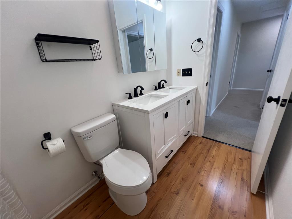 896 Briarstone Road Bethlehem, PA 18017 - Photo 29 of 37 Rich wood flooring grounds this modern bathroom featuring a clean white double vanity.