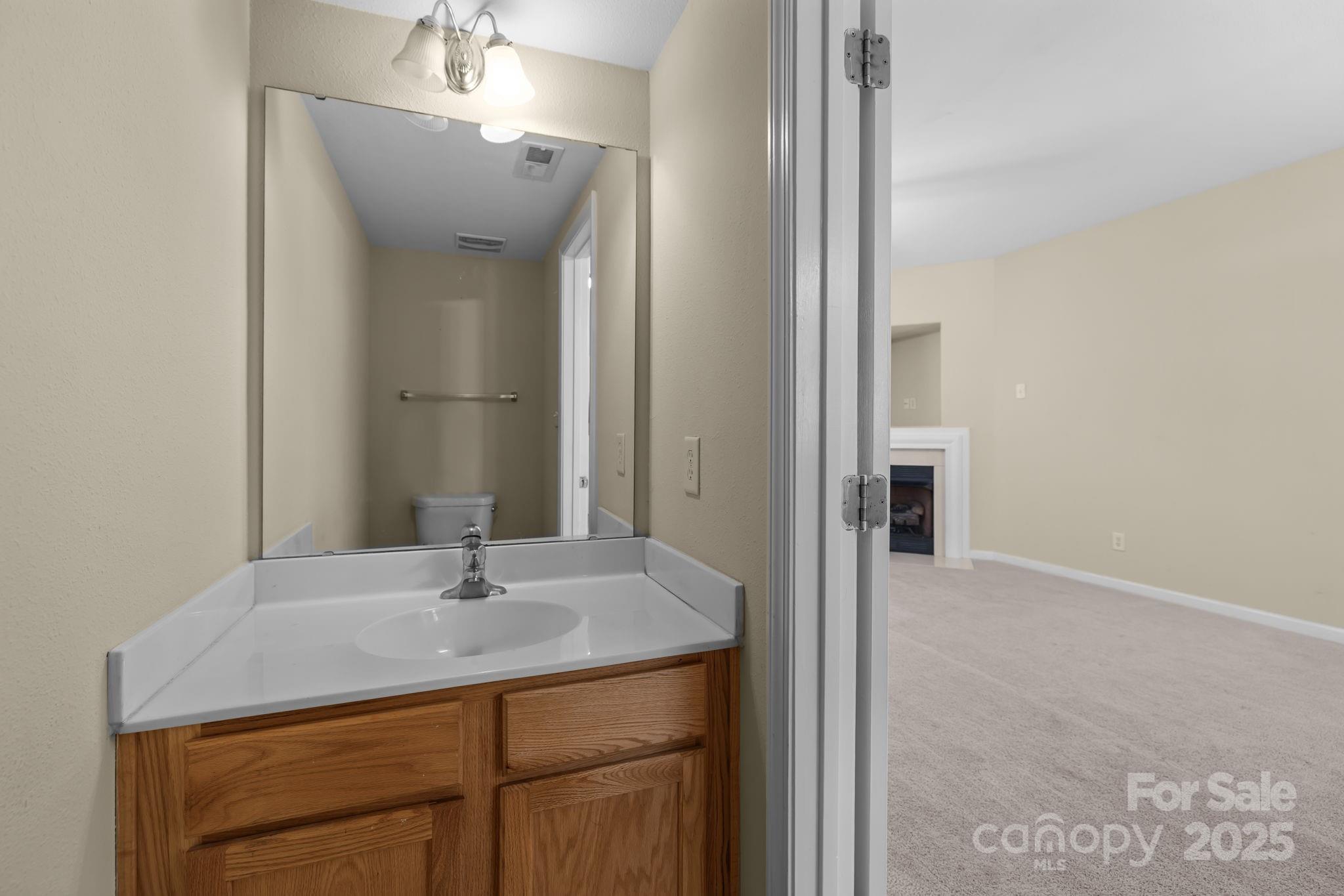 8809 Starnes Randall Road Charlotte, NC 28215 - Photo 13 of 28 a bathroom with a sink a vanity and a mirror