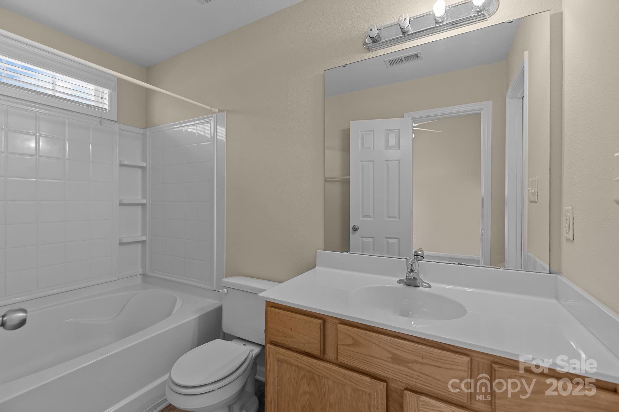 8809 Starnes Randall Road Charlotte, NC 28215 - Photo 19 of 28 a bathroom with a granite countertop sink a toilet and shower
