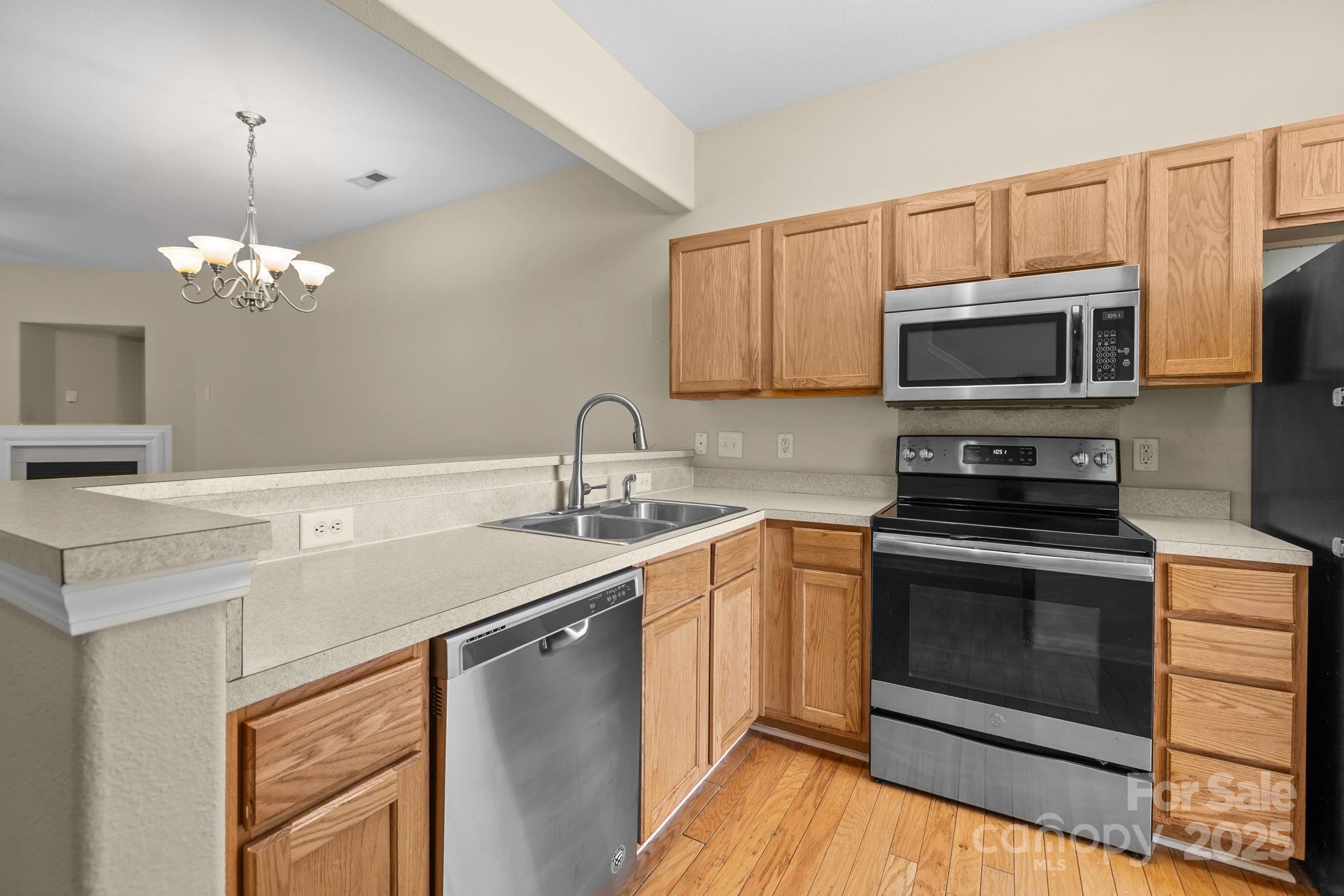 8809 Starnes Randall Road Charlotte, NC 28215 - Photo 5 of 28 a kitchen with stainless steel appliances a stove microwave and sink