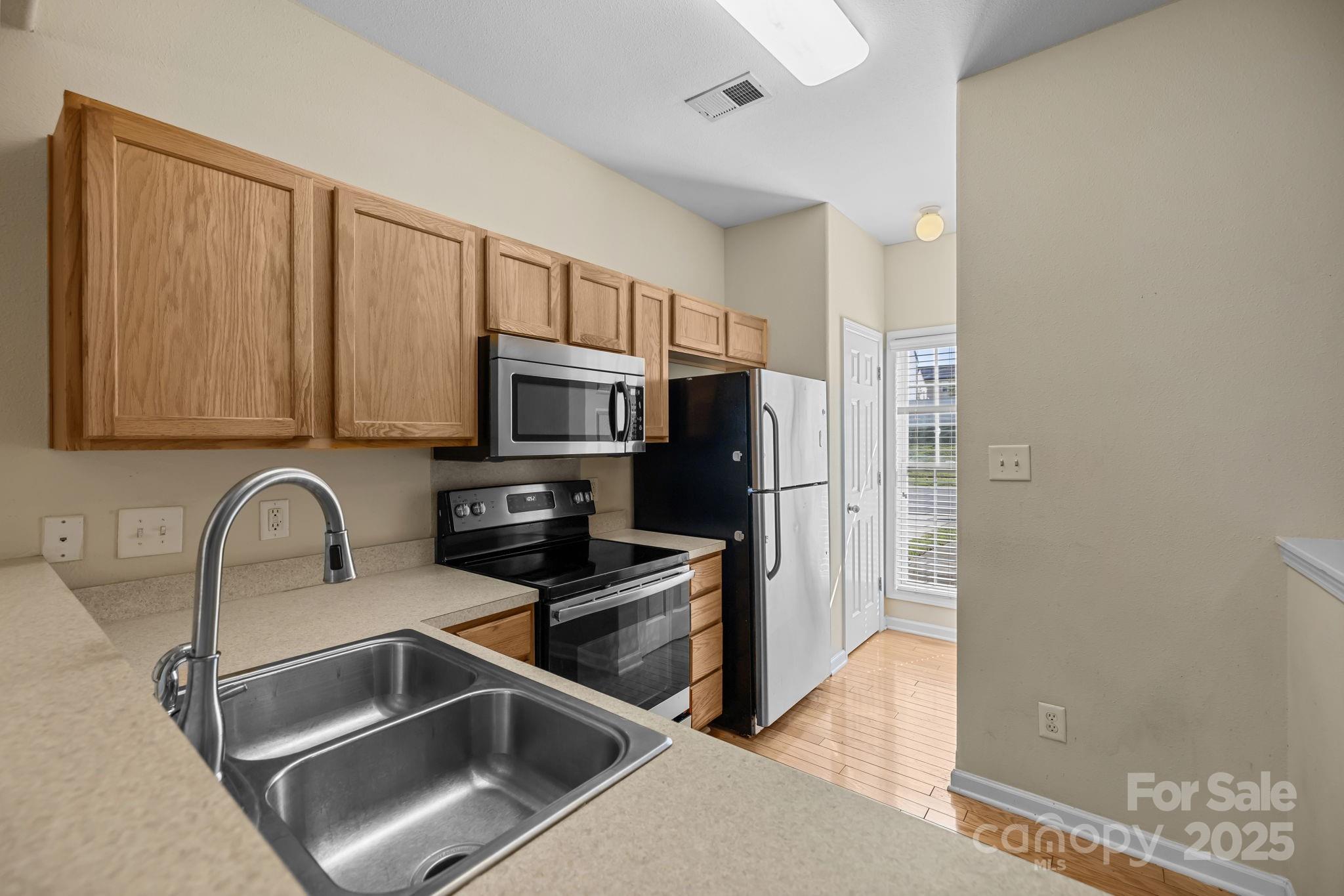 8809 Starnes Randall Road Charlotte, NC 28215 - Photo 6 of 28 a kitchen with stainless steel appliances granite countertop a sink and a refrigerator