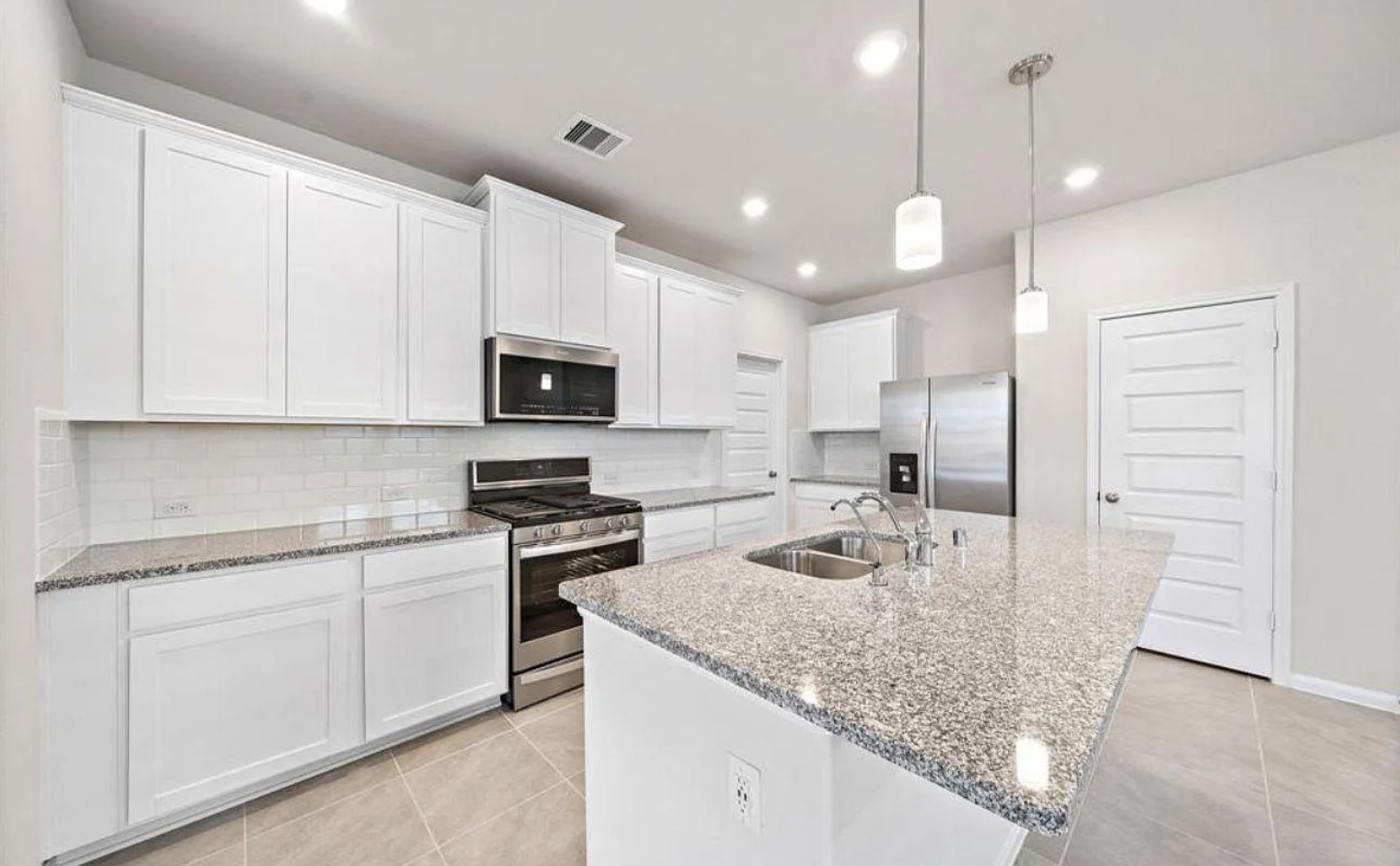 5631 Giving Grace Way Houston, TX 77048 - Photo 3 of 10 a kitchen with white cabinets and stainless steel appliances