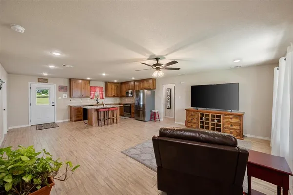 a living room with furniture a dining table and kitchen view