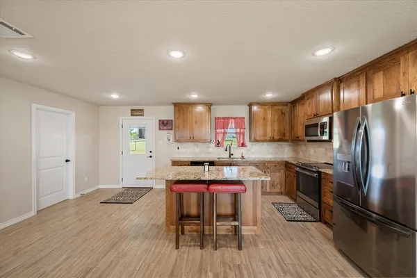 a kitchen with sink refrigerator and microwave