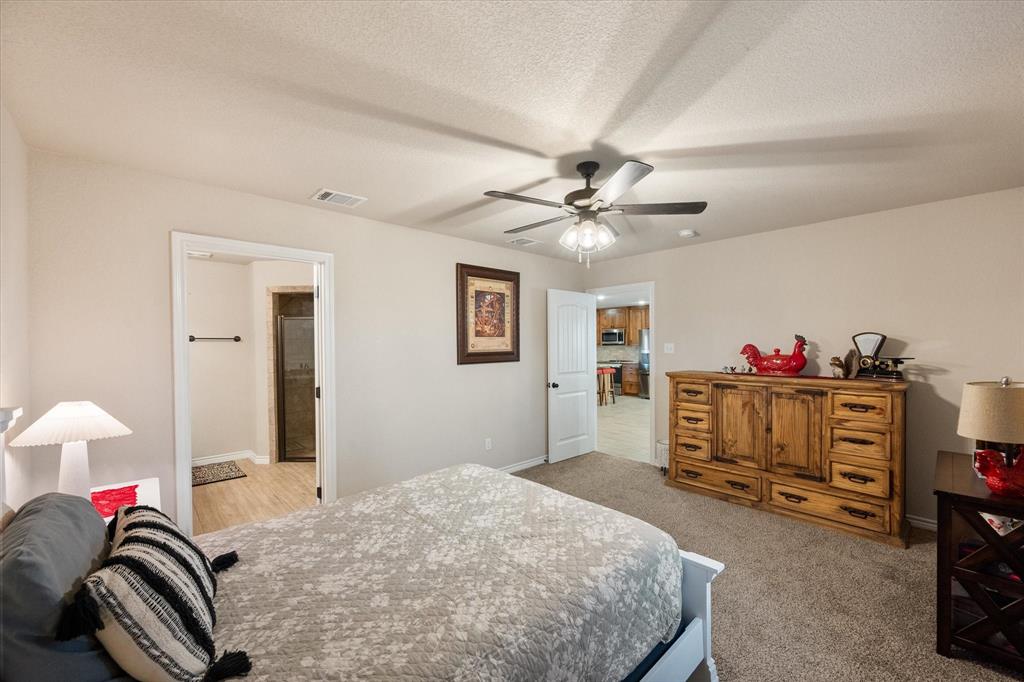 2004 Brown Loop Poolville, TX 76487 - Photo 22 of 36 a bedroom with a bed and a chandelier