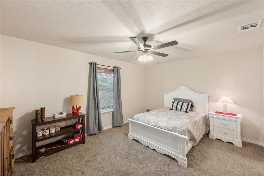 2004 Brown Loop Poolville, TX 76487 - Photo 23 of 36 a bedroom with a bed and a chandelier