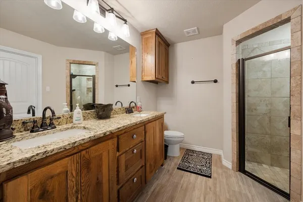 a bathroom with a granite countertop sink a toilet and a mirror
