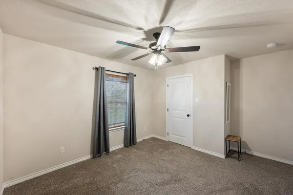 a view of an empty room with a ceiling fan