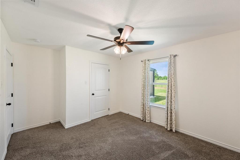 2004 Brown Loop Poolville, TX 76487 - Photo 27 of 36 a view of an empty room with a ceiling fan