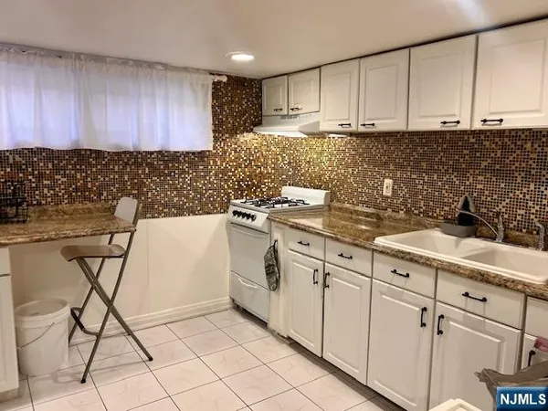 a kitchen with granite countertop white cabinets and white appliances