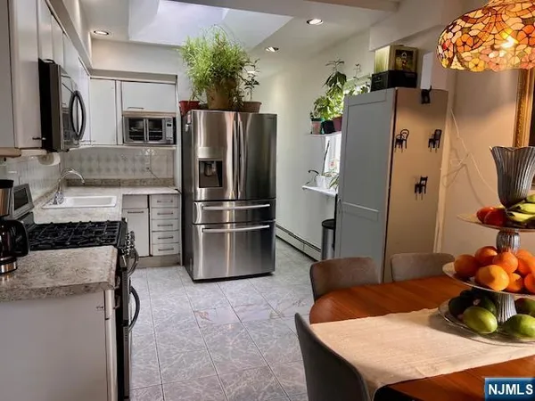 a kitchen with stainless steel appliances granite countertop a refrigerator a stove and a sink