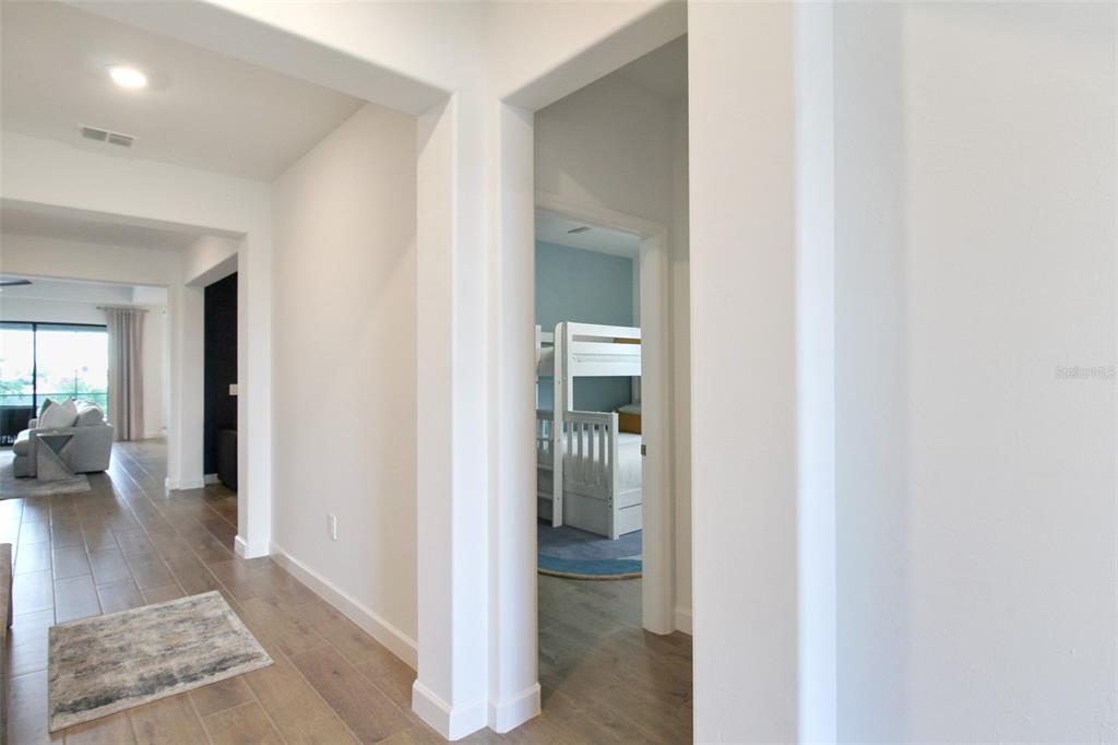 15025 Sea Salt Way Bradenton, FL 34211 - Photo 13 of 64 a view of a hallway with wooden floor and a living room