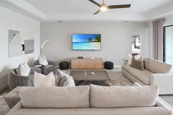 a living room with furniture kitchen view and a chandelier