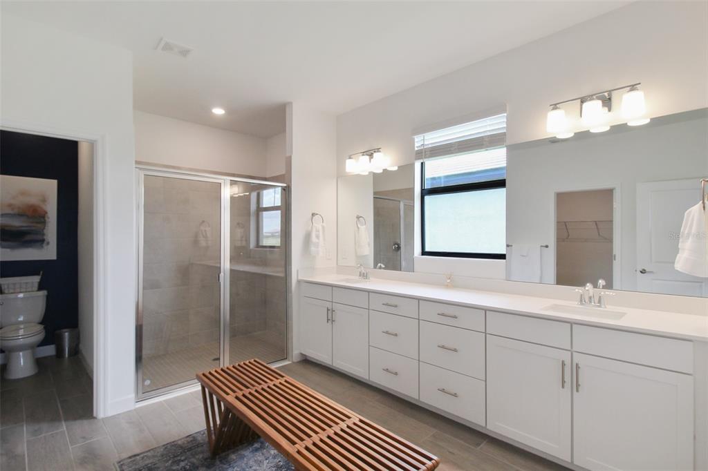 15025 Sea Salt Way Bradenton, FL 34211 - Photo 44 of 64 a spacious bathroom with a double vanity sink a mirror and a shower