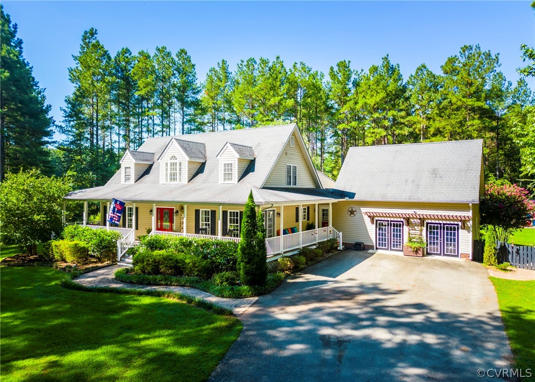 a view of a white house with a big yard and potted plants
