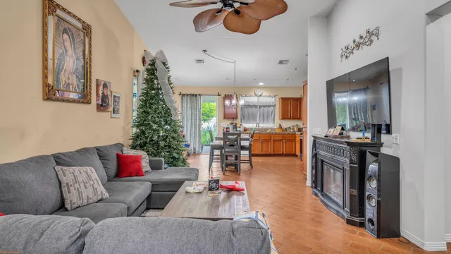 a living room with furniture kitchen view and a large window