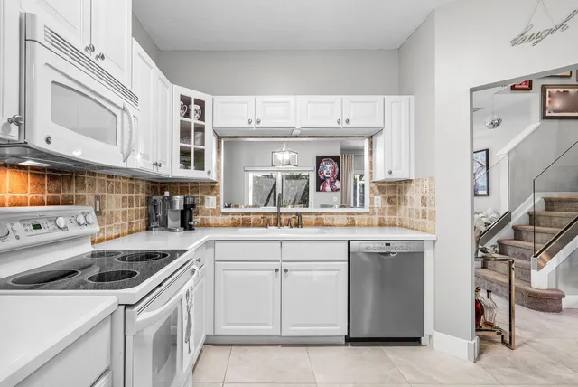 a kitchen with a sink a stove and cabinets