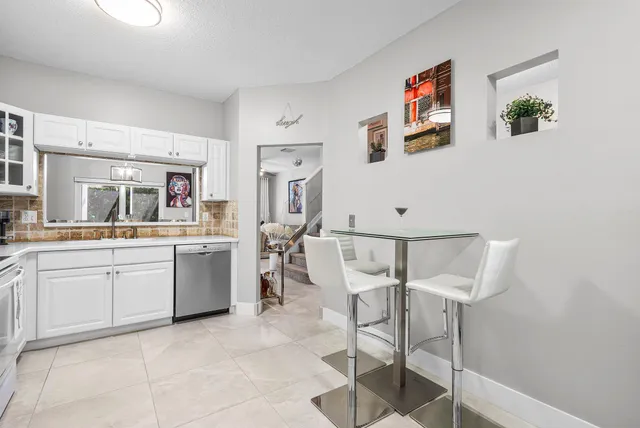 a kitchen with cabinets and chairs