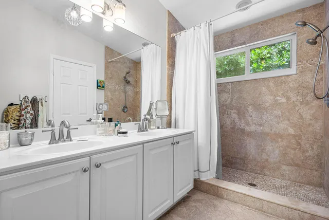 a bedroom with a bed and a large mirror on the dresser