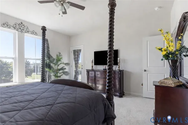 a bedroom with a bed flat screen tv and a large window