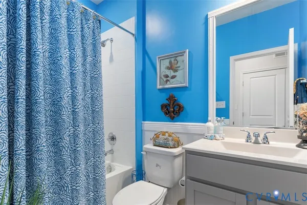 a bathroom with a granite countertop sink and a toilet