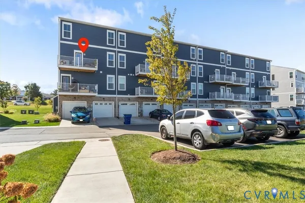 a front view of building with outdoor space and trees in the background