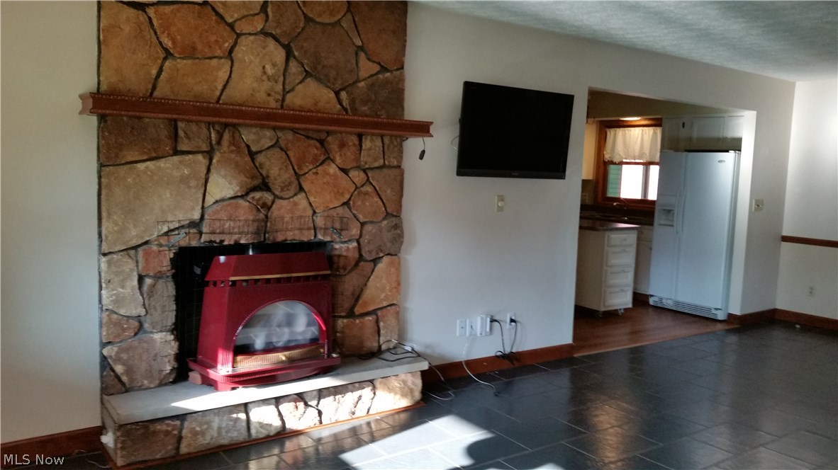 2376 Haines Road Madison, OH 44057 - Photo 6 of 30 The stone to the ceiling wood burning fireplace has a insert for heat efficiency.