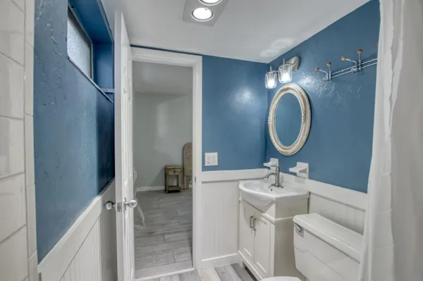 a bathroom with a toilet sink and mirror