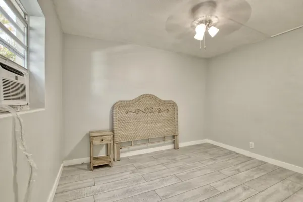 an empty room with a wooden floor and chandelier