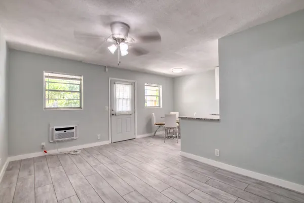 a view of empty room with wooden floor and fan