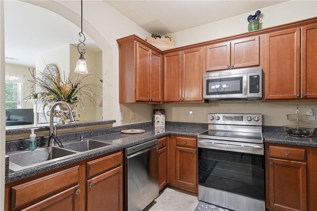 608 Myers Gate Road Ball Ground, GA 30107 - Photo 6 of 31 a kitchen with stainless steel appliances granite countertop a sink stove and microwave
