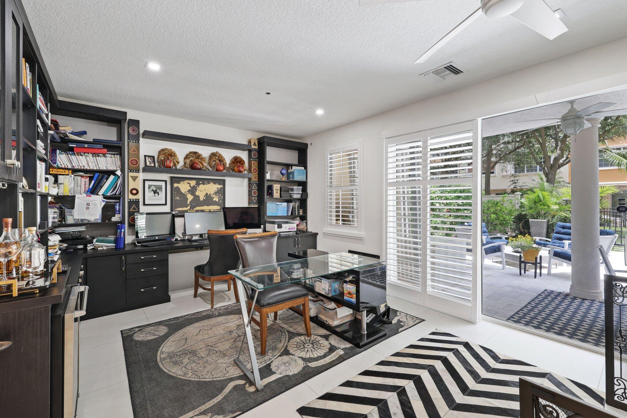 5530 Northeast Trieste Terrace, Unit 5530 Boca Raton, FL 33487 - Photo 12 of 57 a living room with furniture a bookshelf and a large window