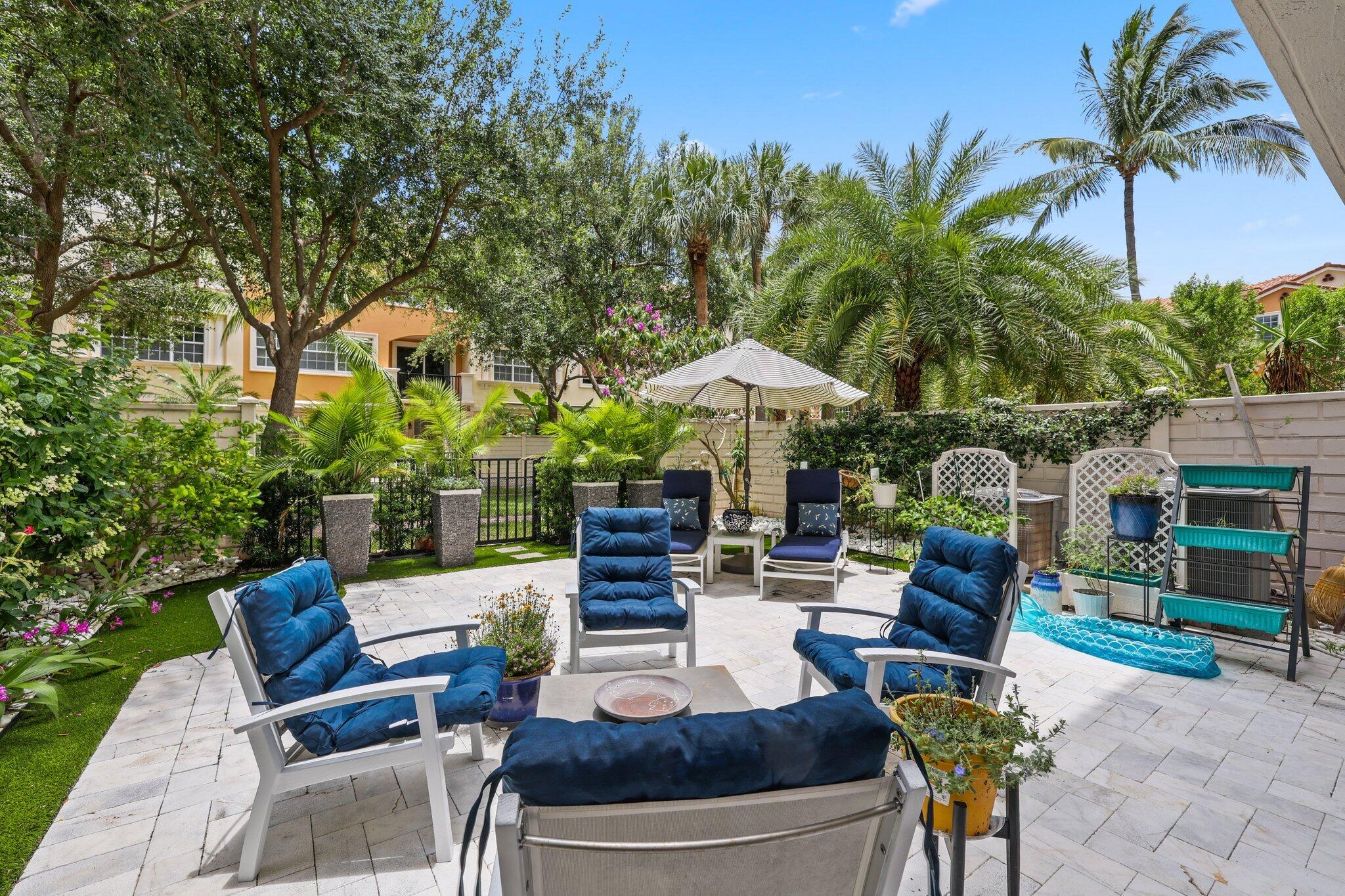 5530 Northeast Trieste Terrace, Unit 5530 Boca Raton, FL 33487 - Photo 17 of 57 a view of patio with chairs and tables with potted plants