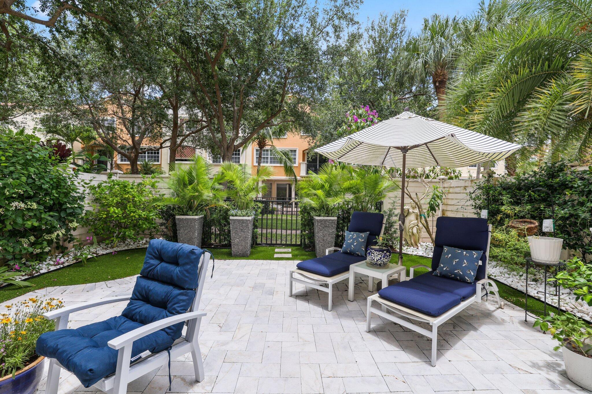 5530 Northeast Trieste Terrace, Unit 5530 Boca Raton, FL 33487 - Photo 18 of 57 a view of a chairs and table in the back yard