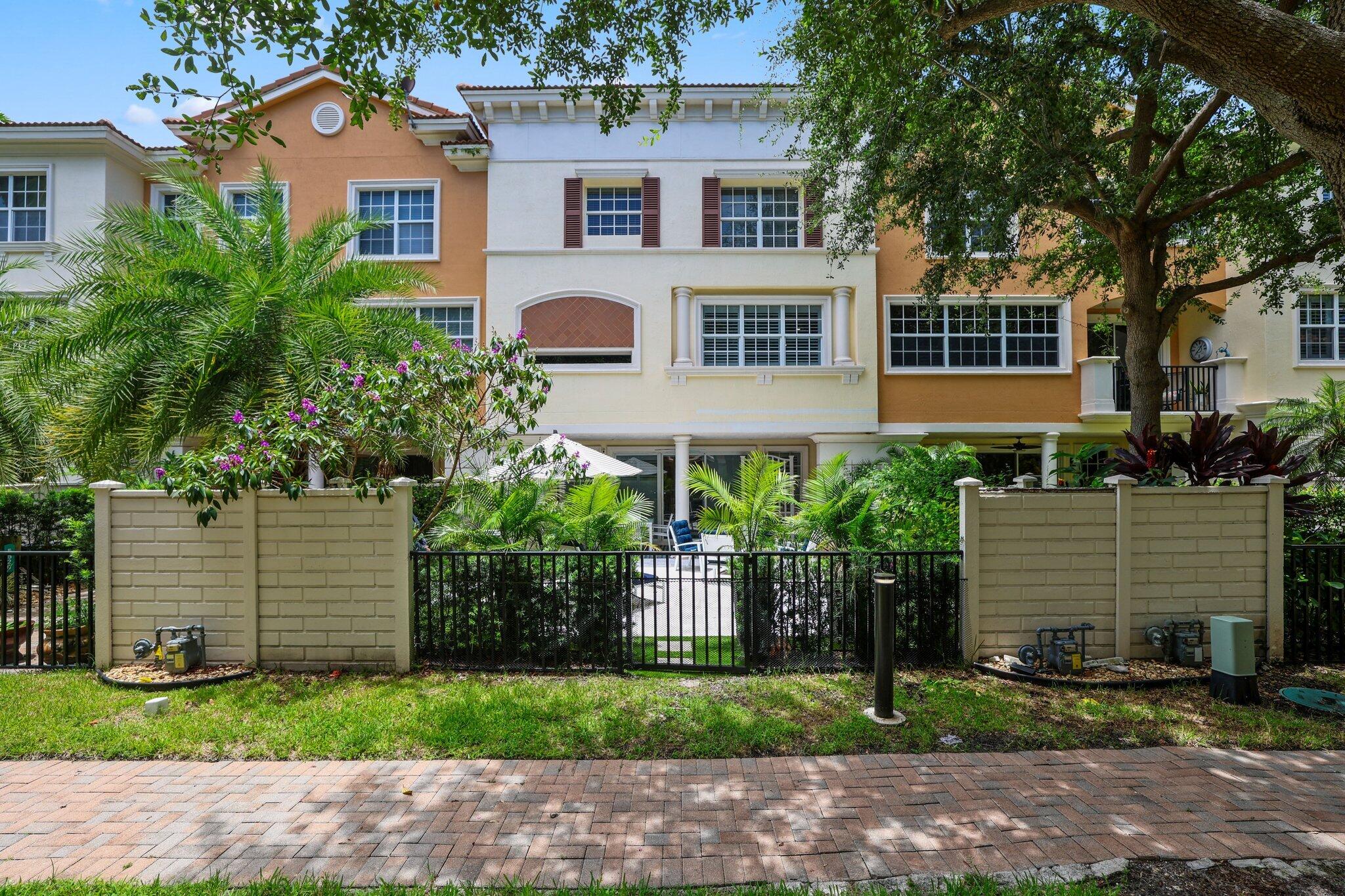 5530 Northeast Trieste Terrace, Unit 5530 Boca Raton, FL 33487 - Photo 20 of 57 a front view of a house with a yard and potted plants