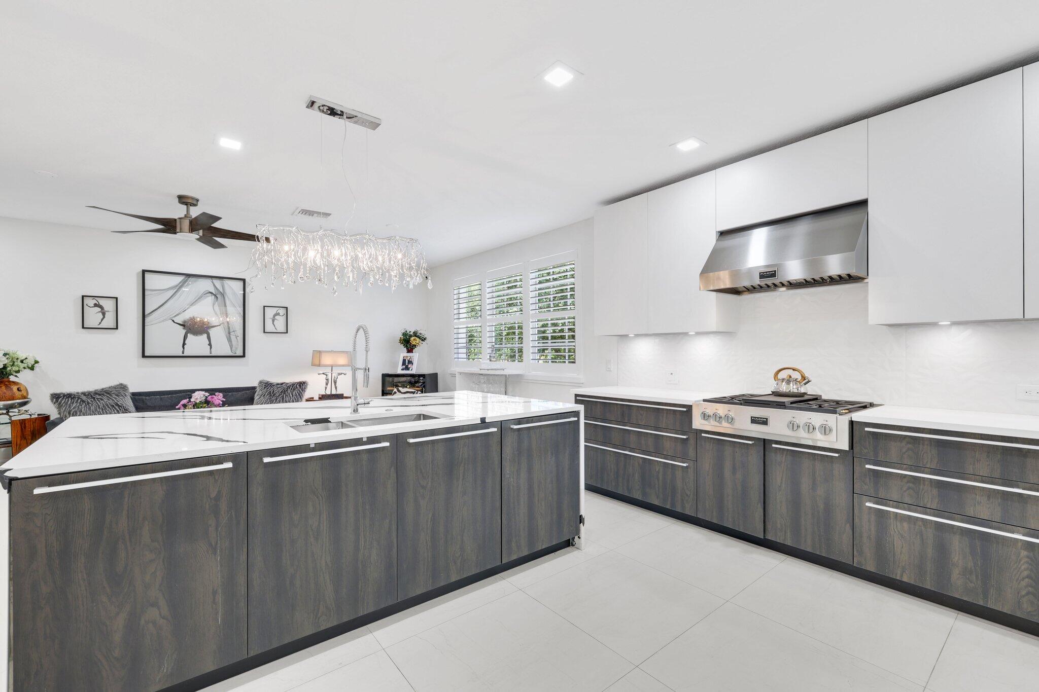 5530 Northeast Trieste Terrace, Unit 5530 Boca Raton, FL 33487 - Photo 27 of 57 a kitchen with lots of counter top space sink and stainless steel appliances