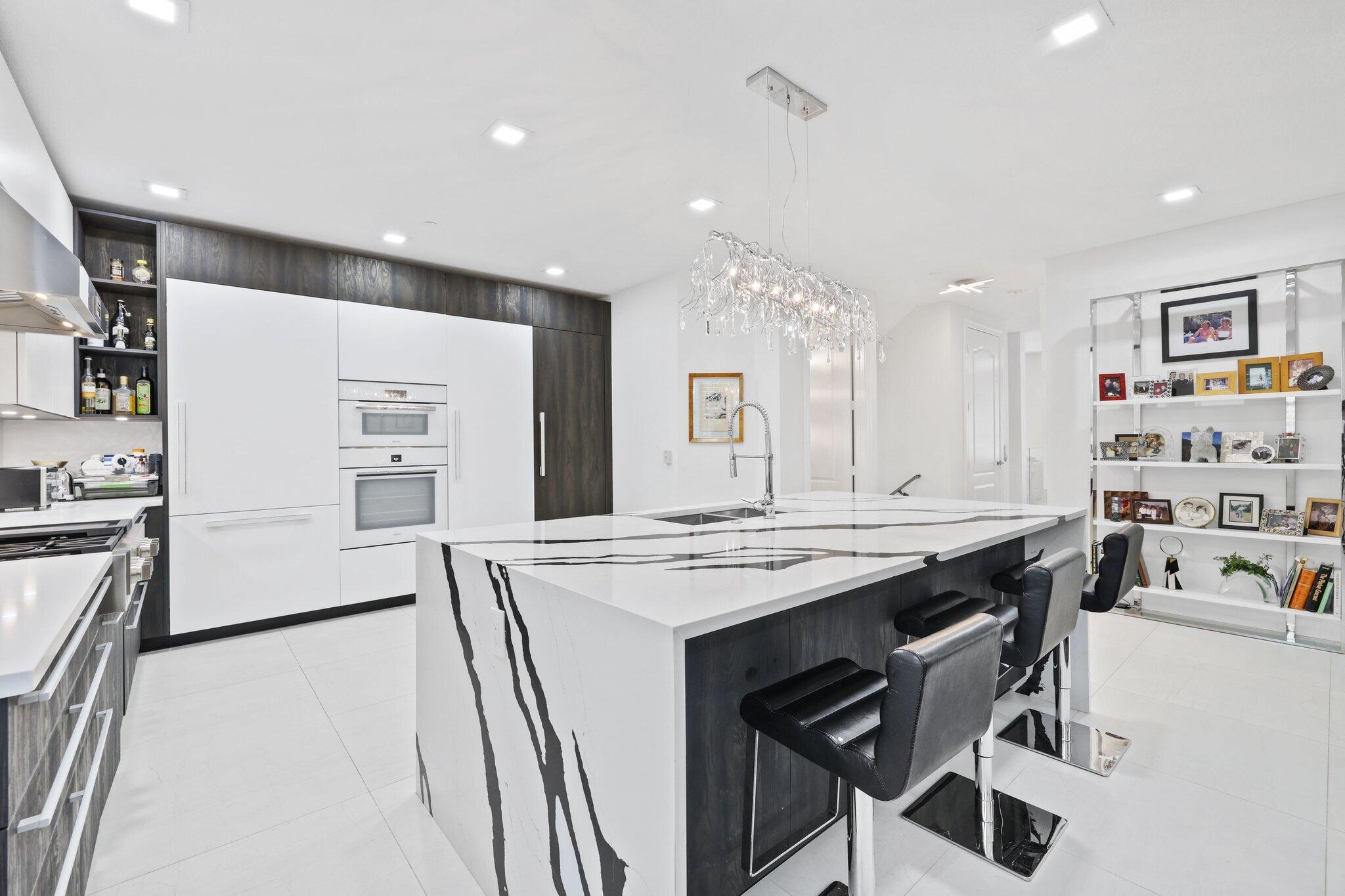 5530 Northeast Trieste Terrace, Unit 5530 Boca Raton, FL 33487 - Photo 30 of 57 a kitchen that has a lot of cabinets in it and wooden floors