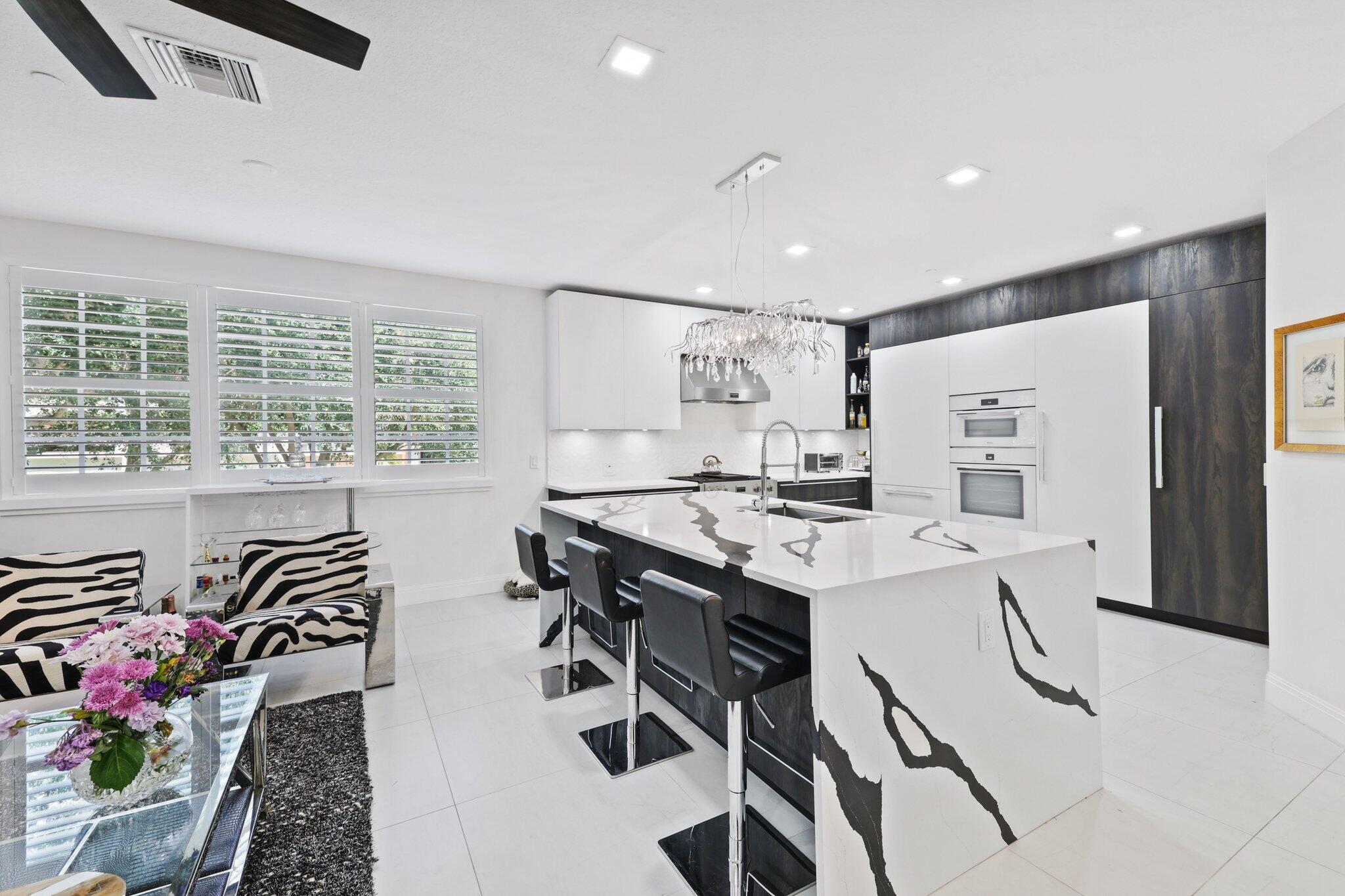 5530 Northeast Trieste Terrace, Unit 5530 Boca Raton, FL 33487 - Photo 31 of 57 a kitchen that has a table and chairs in it