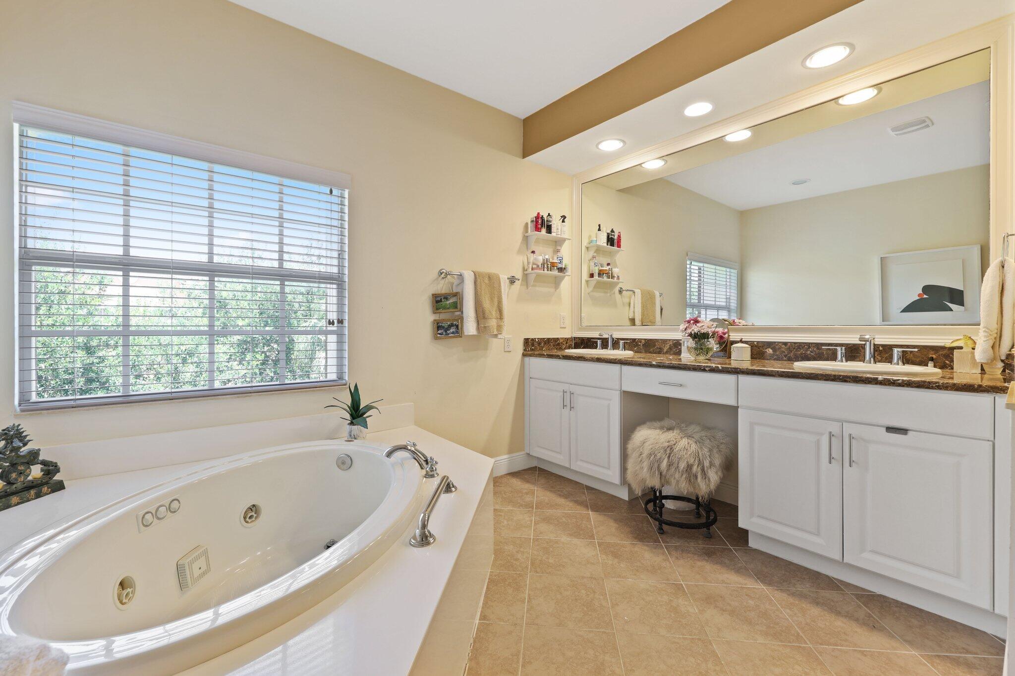 5530 Northeast Trieste Terrace, Unit 5530 Boca Raton, FL 33487 - Photo 48 of 57 a spacious bathroom with a double vanity sink mirror and bathtub