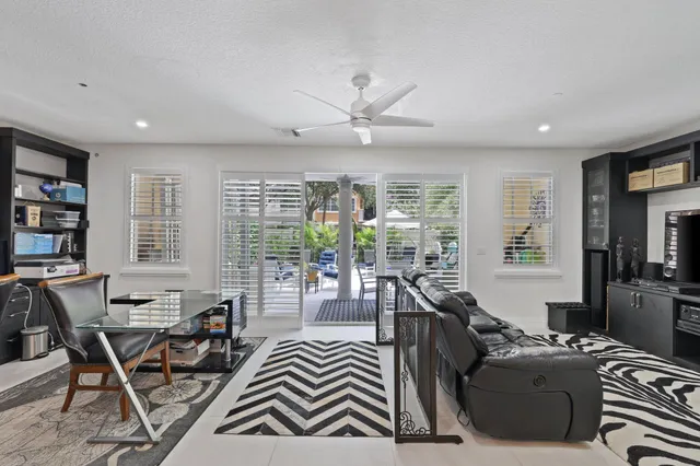 a living room with furniture a bookshelf and a large window