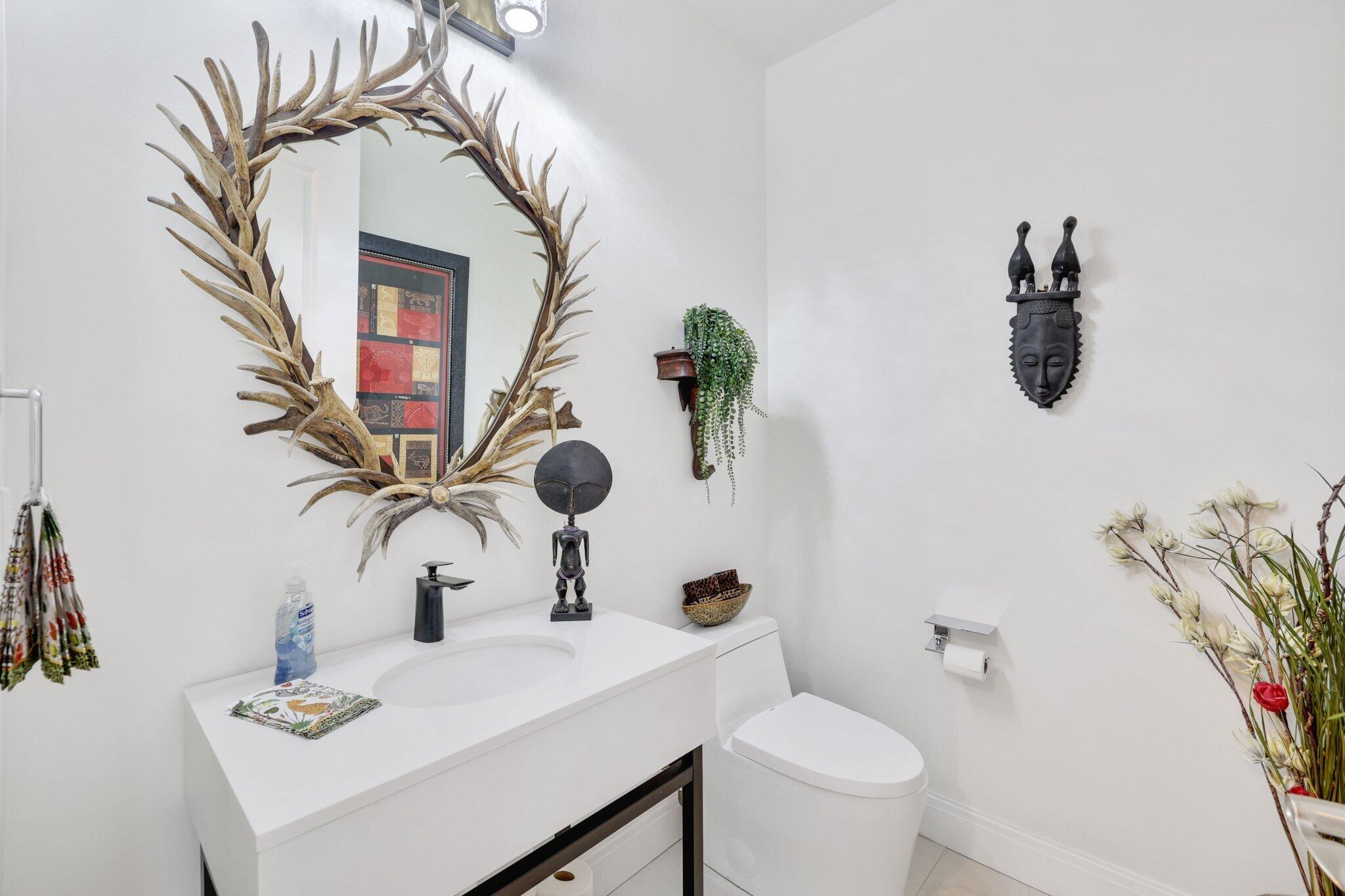 5530 Northeast Trieste Terrace, Unit 5530 Boca Raton, FL 33487 - Photo 10 of 57 a bathroom with a sink a toilet and mirror