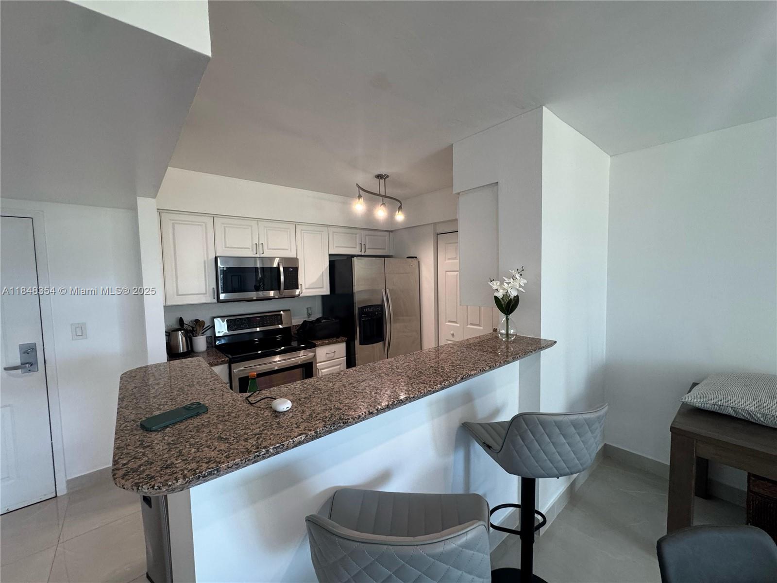 1155 Brickell Bay Drive, Unit 307 Miami, FL 33131 - Photo 11 of 23 a large kitchen with a table and chairs