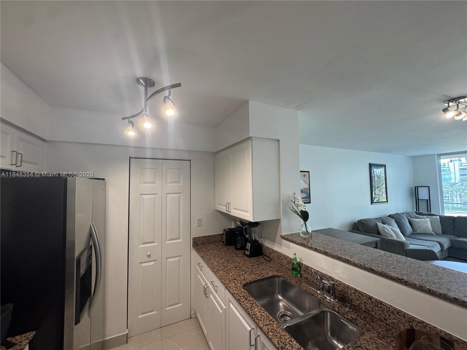 1155 Brickell Bay Drive, Unit 307 Miami, FL 33131 - Photo 12 of 23 a kitchen with stainless steel appliances granite countertop a sink stove and refrigerator