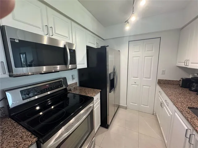 a kitchen with stainless steel appliances kitchen island granite countertop a stove and a refrigerator