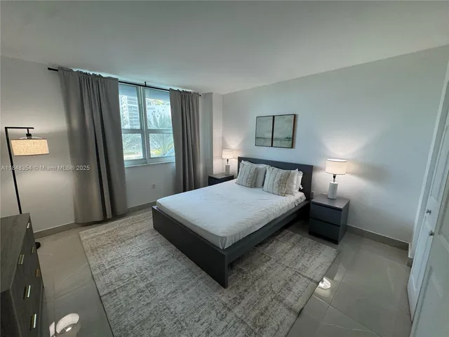 a bedroom with a bed lamp and window